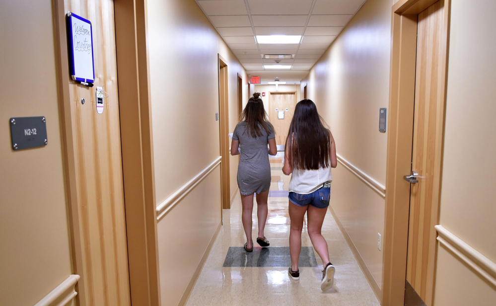 Taylor Peno, left, and Makenzie Carlow walk down a hallway Friday at Hinman Hall at Thomas College in Waterville after moving into their room.