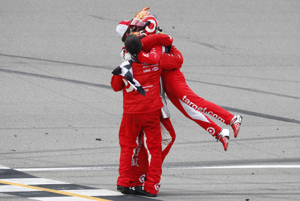Kyle Larson celebrates with crew members after winning the NASCAR Sprint Cup Series race Sunday at Michigan International Speedway in Brooklyn, Michigan.