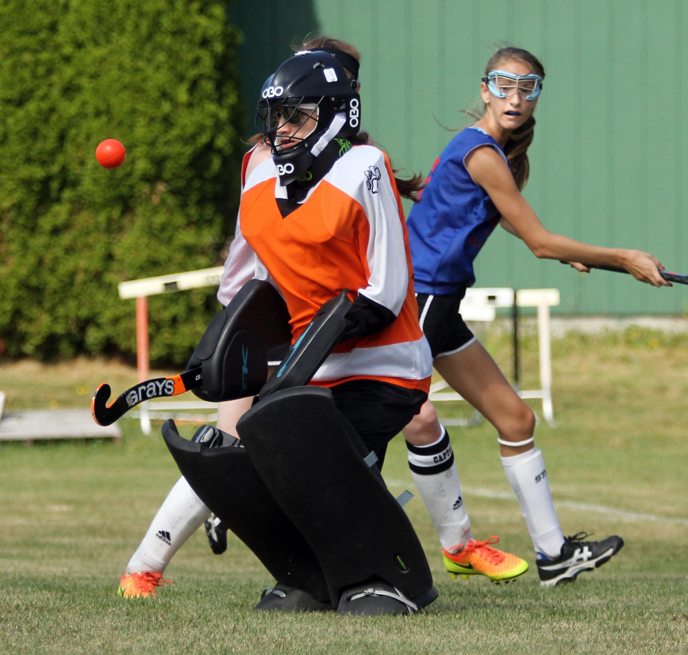 Gardiner Area High School goalie Avery Backus keeps her eyes on the ball as Messalonskee High School's Megan Quirion looks back at the play during a field hockey scrimmage in Winslow on Saturday.