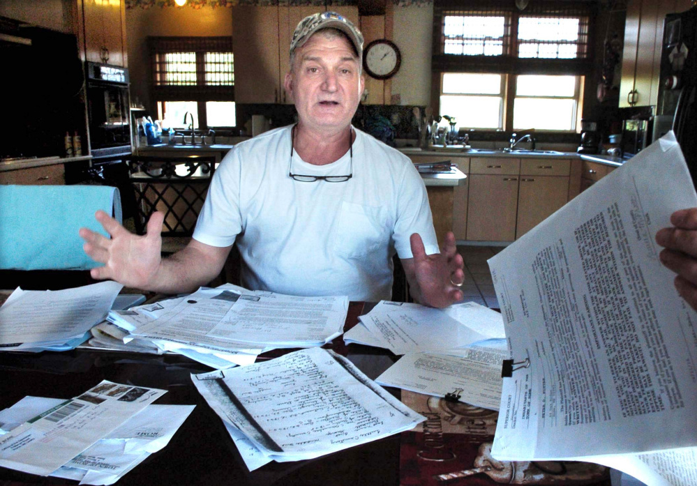 Surrounded by documents and legal papers, Rome resident Peter Fotter talks on Tuesday about a recent dispute with Rome officials regarding access to the Tuttle Cemetery on his property.
