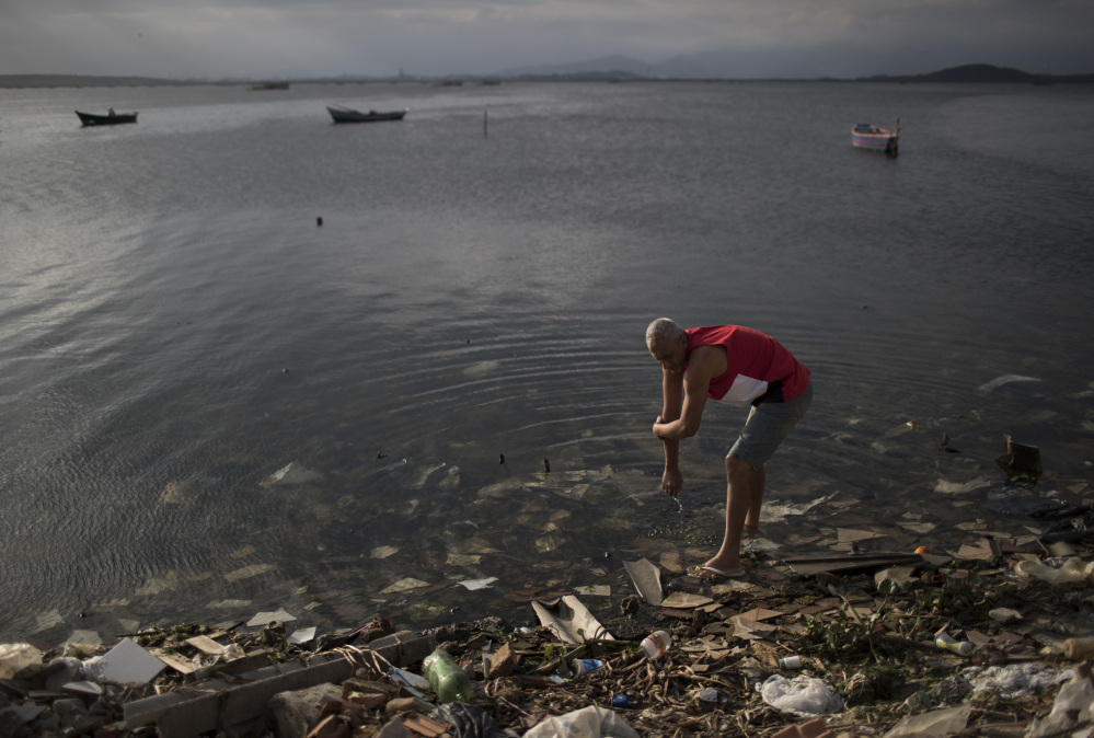 A man washes himself in the polluted waters of Guanabara Bay in Rio de Janeiro, Brazil, on Saturday. While authorities including Mayor Eduardo Paes have acknowledged the failure of the city's water cleanup efforts, calling it a "lost chance" and a "shame," Olympic officials insist that Rio's waterways will be safe for athletes and visitors.