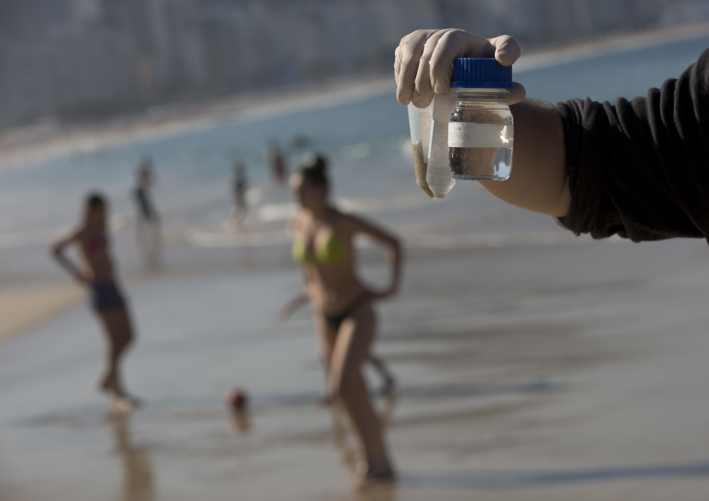 Doctoral candidate Rodrigo Staggemeier shows samples of water and sand from Copacabana Beach in Rio de Janeiro, collected July 11 for a study commissioned by The Associated Press. The 16-month review of the aquatic Olympic and Paralympic venues has revealed consistent and dangerously high levels of illness-causing viruses from sewage pollution.