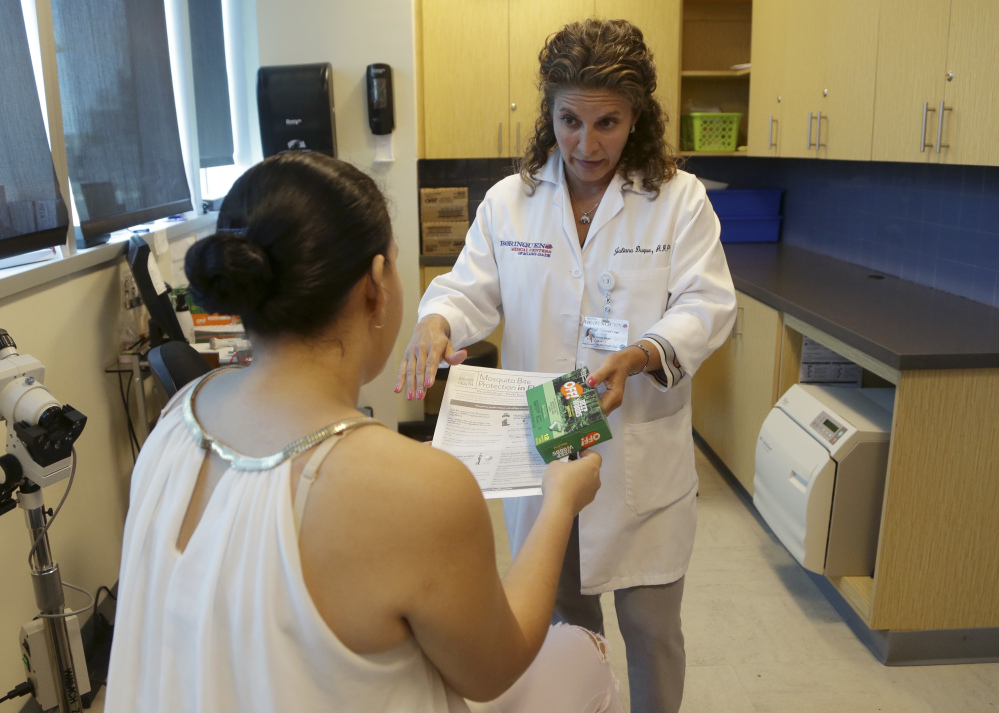 Dr. Juliana Duque gives a patient, who is in her first trimester of pregnancy, insecticide and information about mosquito protection at the Borinquen Medical Center on Tuesday in Miami. The CDC has advised pregnant women to avoid travel to the nearby neighborhood of Wynwood where mosquitoes are apparently transmitting Zika directly to humans.