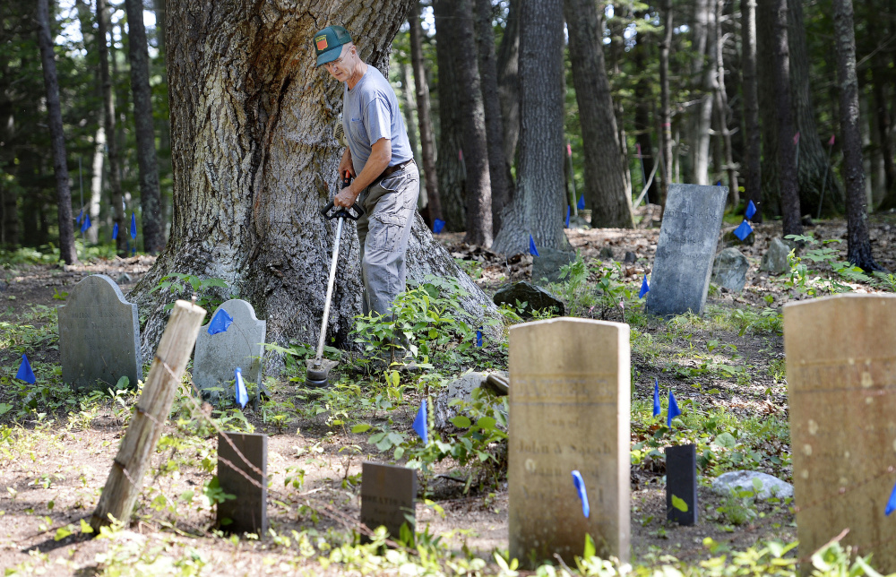 Ken Mann tends to graves in Mann Cemetery last week. He and other Freeport residents want to restore public access to the 18th-century graveyard across land owned by L.L. Bean.