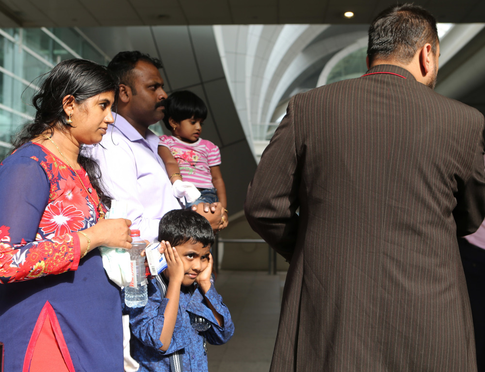 A family is helped to a taxi after safely evacuating a plane that crash-landed and caught fire Wednesday in Dubai, halting all traffic at the Middle East's busiest airport.