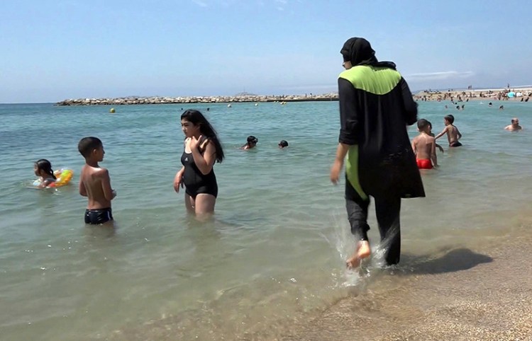 A Muslim woman on the beach in Marseille, France wearing a so-called burkini which has been banned in nearby Cannes.