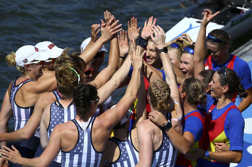 The women's rowing teams from the United States, left, and Romania celebrate on the dock after winning medals in the women's eight event at the Olympics on Saturday in Rio de Janeiro. Romania took the bronze, the United states the gold and Britain the silver.