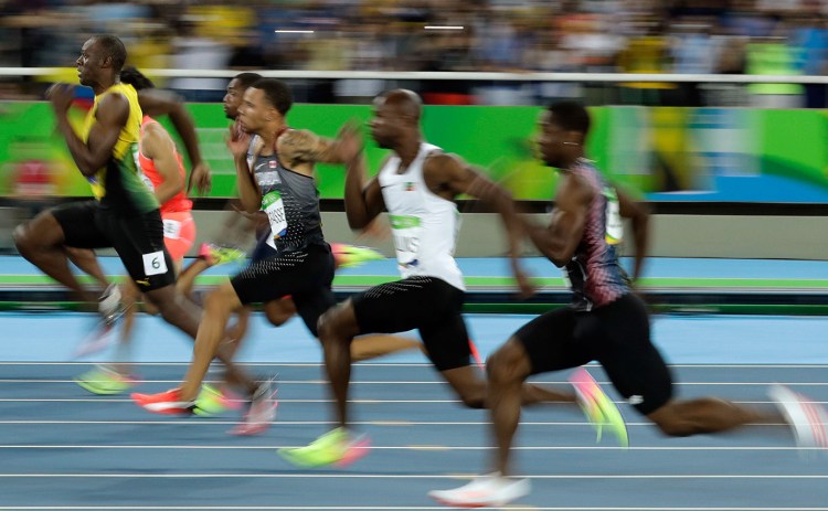 Jamaica's Usain Bolt, left, takes the lead in a men's 100-meter semifinal during the athletics competitions of the 2016 Summer Olympics at the Olympic stadium in Rio de Janeiro, Brazil, Sunday.
