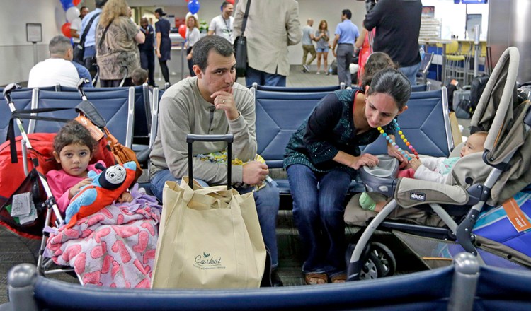 Mario Martinez and his wife Nimaris Niebla wait with their children to depart Fort Lauderdale-Hollywood International Airport in Fort Lauderdale, Fla., Wednesday on a flight to Santa Clara, Cuba, to visit their family. Alan Diaz/Associated Press