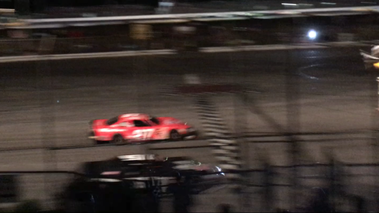 This still image, taken from cell phone video, shows the cars of Wayne Helliwell (orange) and Joey Polewarczyk at the finish line of Sunday night's PASS HP Hood 150 at Oxford Plains Speedway. On Monday morning, the finish was declared a dead heat by series officials.