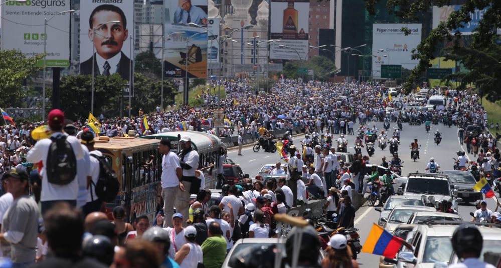 Demonstrators take part in the  "Taking of Caracas" march in Caracas, Venezuela, Thursday, as the opposition vowed to keep up pressure on President Nicolas Maduro