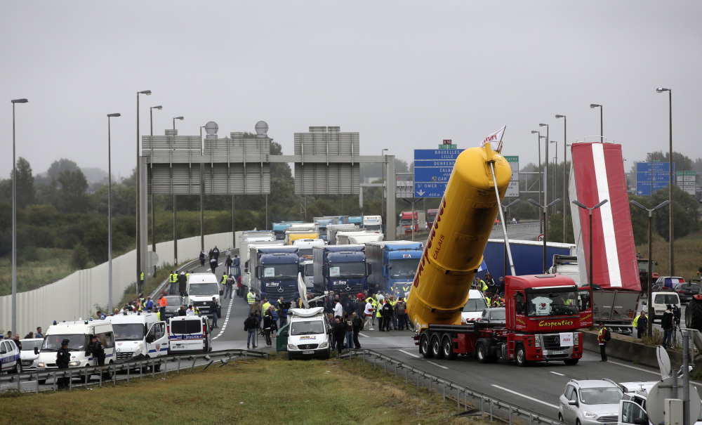 Truckers block a road Monday near the French port of Calais as they demand closure of a camp known as the "Jungle," where 7,000 to 9,000 refugees and migrants, mostly from Afghanistan and Sudan, live in squalid conditions and legal limbo.
