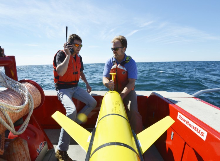 Woods Hole Oceanographic Institution engineers prepare to release a drone off Martha's Vineyard on Sept. 2. The 'ocean gliders' allow researchers to collect data on water temperatures, salinity and density before and after storms.