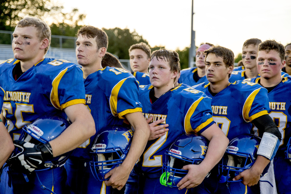 FALMOUTH, ME - SEPTEMBER 9: Shane Allen of Falmouth, center, stands at attention with his teammates as they listen to the national anthem before the start of a high school football game vs. Westbrook September 9, 2016. (Photo by Gabe Souza/Staff Photographer)