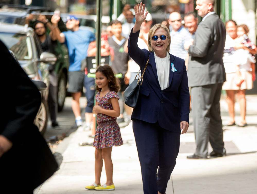 Democratic presidential candidate Hillary Clinton, seen waving Sunday, left the 9/11 anniversary ceremony in New York early after feeling "overheated," her campaign said.