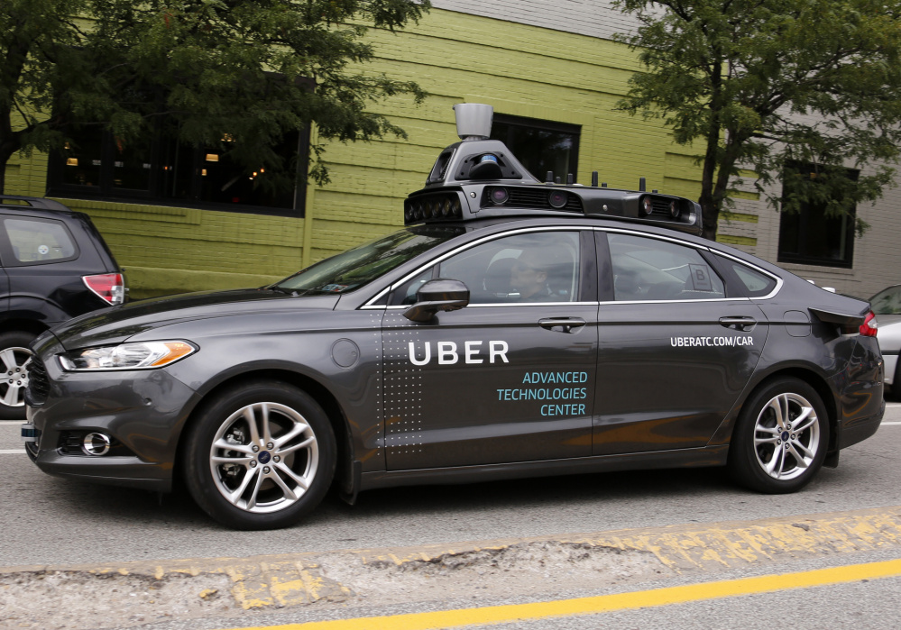 A self-driving Uber car travels through a neighborhood Wednesday in Pittsburgh. About 1,000 Uber customers were offered a free ride in an automated car, each of which had a safety driver and a vehicle operator in the front seats.