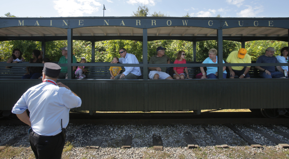 Volunteer conductor Brian Tutlis waits for passengers to reboard the train after a stop along Portland's waterfront. A plan for Gray to put nearly $500,000 into a project to move the operation to the town has proponents and detractors.