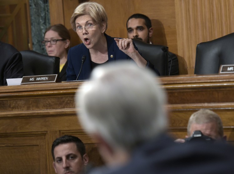 Senate Banking Committee member Elizabeth Warren, D-Mass., blasts Wells Fargo CEO John Stumpf, foreground, during the committee's hearing Tuesday. "You squeezed your employees to the breaking point so they would cheat customers," she said. "You should resign."