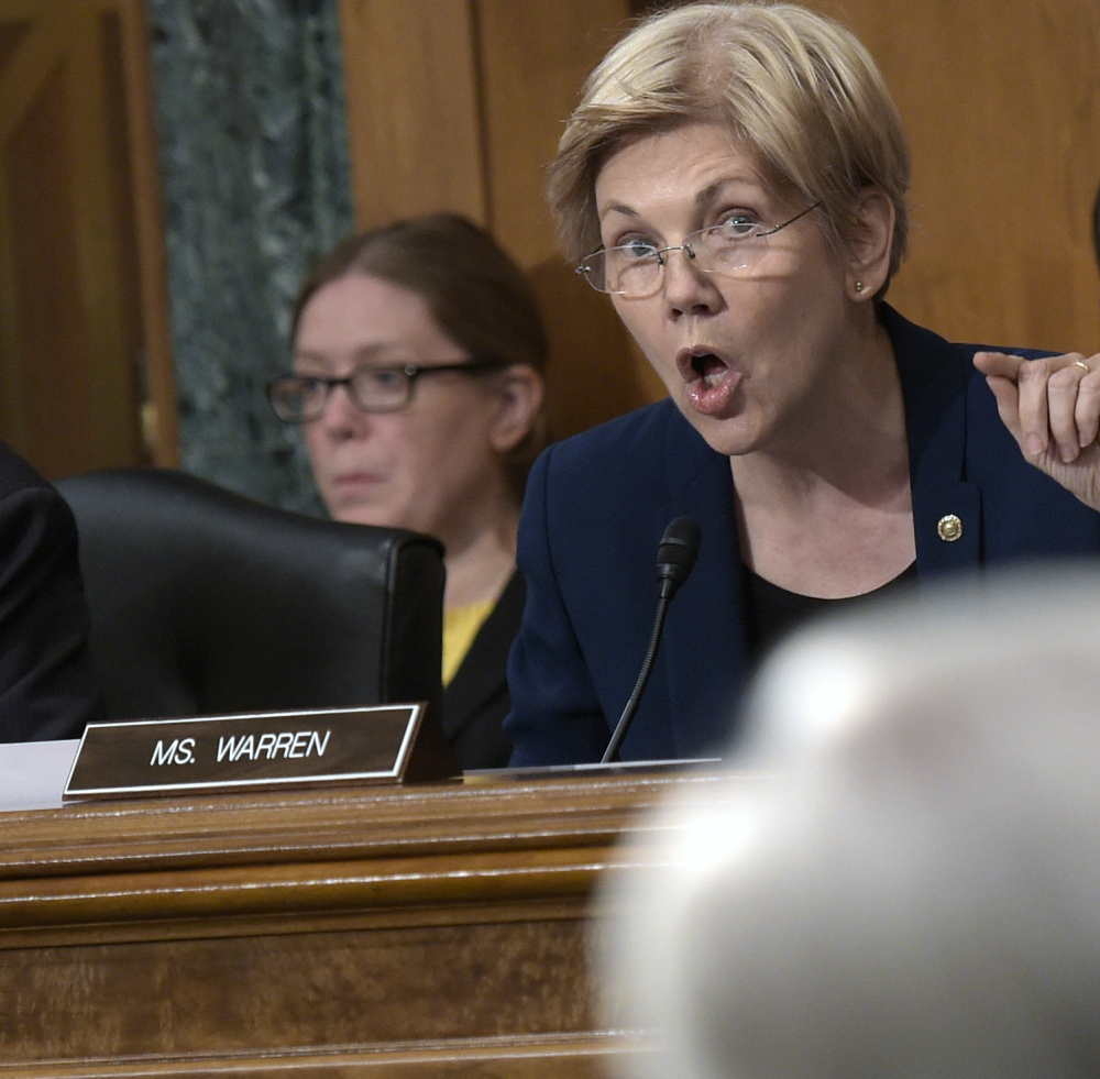 Senate Banking Committee member Sen. Elizabeth Warren, D-Mass., center, questions Wells Fargo CEO John Stumpf, foreground, on Capitol Hill in Washington, Tuesday,