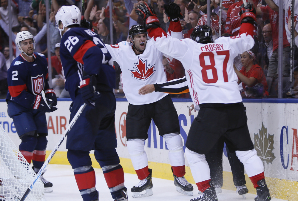 Sidney Crosby, 87, celebrates a Team Canada goal with John Tavares as Team USA defensemen Blake Wheeler, foreground, and Matt Niskanen can only skate away Tuesday night. The U.S. won't advance out of group play after a 4-2 loss.
