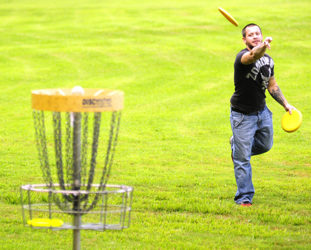 The "holes" in disc golf are usually elevated baskets that capture a disc. Players might carry 10-15 discs in their bag, each with different aerodynamic characteristics.