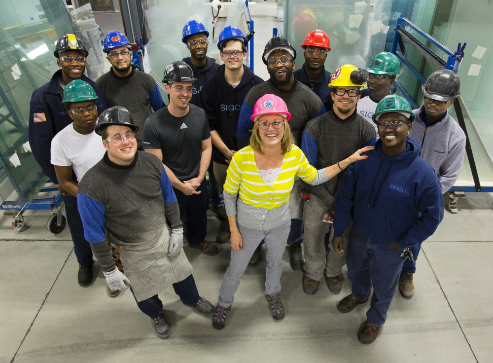 Cindy Caplice, human resources manager at the Sigco fabricating company in Westbrook, stands with some of her workers. Caplice says a focus on hiring African immigrants has been an unqualified success for the company.