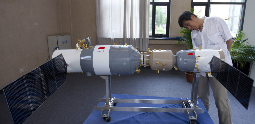 A visitor looks at a replica of China's first space station in Beijing in 2012. Most of the Tiangong 1 is expected to burn up during re-entry in late 2017, a Chinese official says.