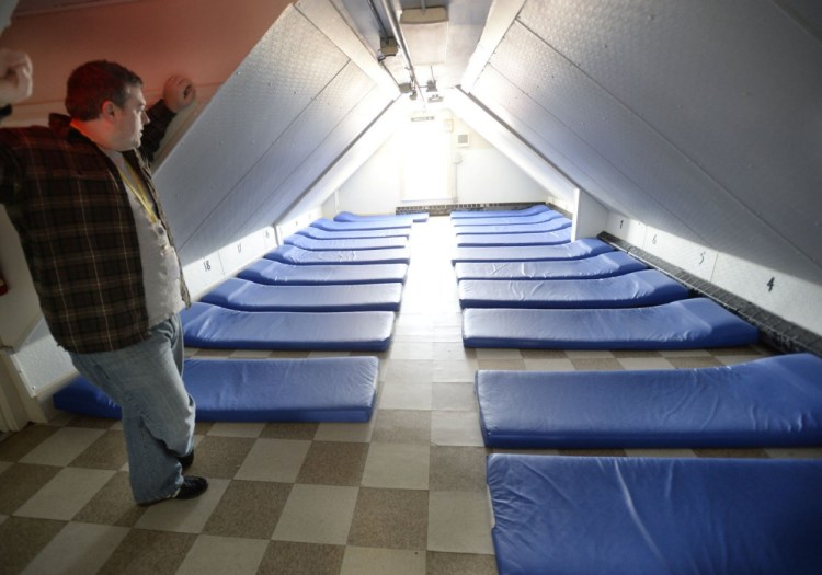 Portland Shelter Director Robert Parritt checks over a room at the Oxford Street Shelter in 2013. Small rooms at the city's shelters are seen as unsafe.