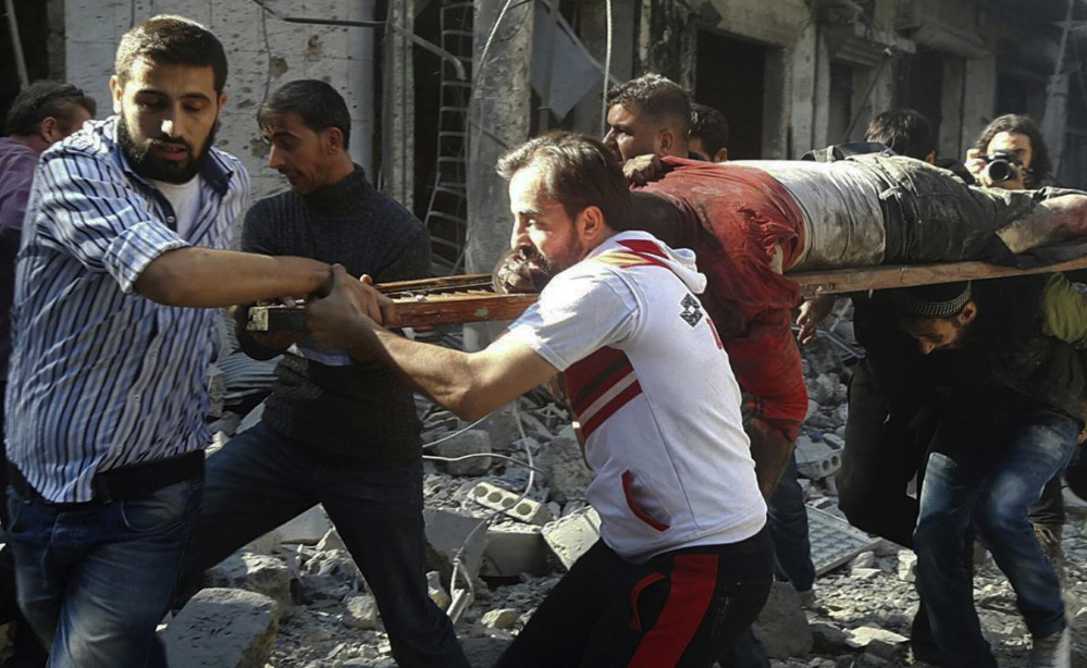 In this photo provided by the Syrian Civil Defense group known as the White Helmets, Syrians carry a victim after airstrikes by government helicopters on the rebel-held Aleppo neighborhood of Mashhad, Syria, Tuesday Sept. 27, 2016. With diplomacy in tatters and a month left to go before U.S. elections, the Syrian government and its Russian allies are using the time to try and recapture the northern city of Aleppo, mobilizing pro-government militias in the Old City and pressing ahead with the most destructive aerial campaign of the past five years. (