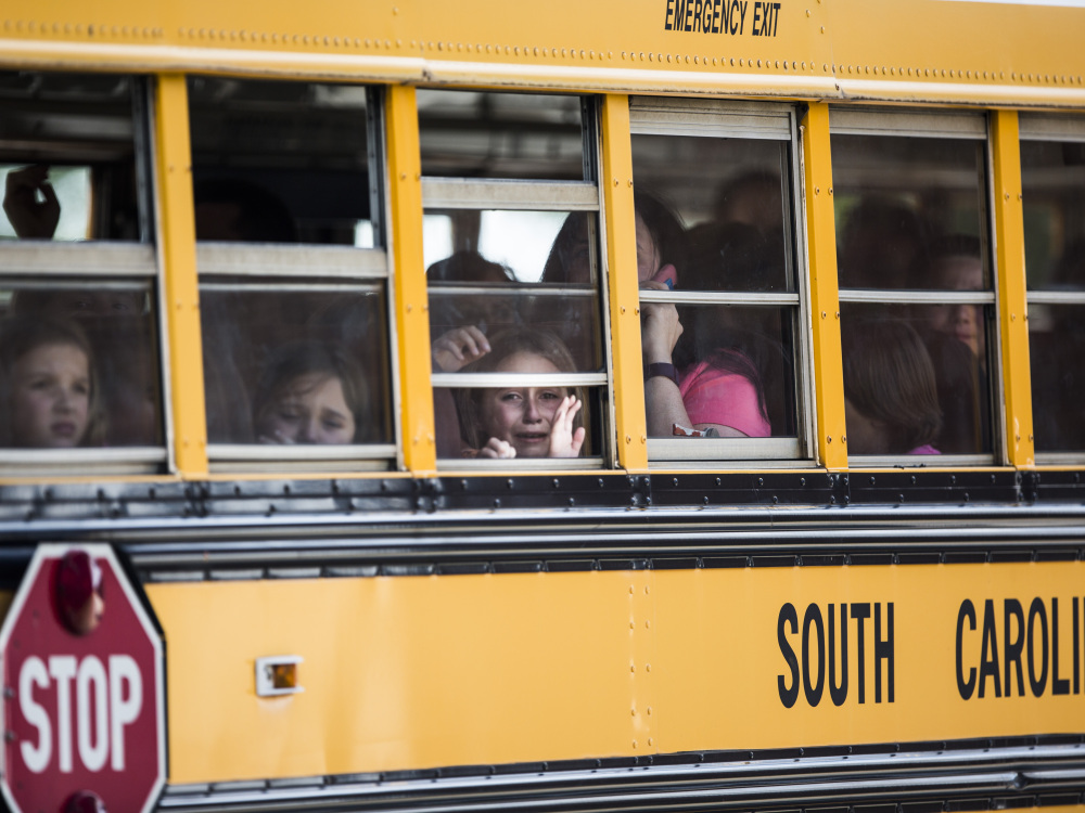 A Townville Elementary student looks out the window of a school bus as she and her classmates are transported to Oakdale Baptist Church, following a shooting at the school in Townville on Wednesday.