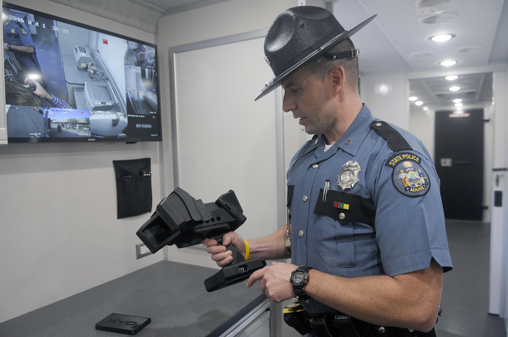 Maine State Police Trooper Aaron Turcotte inspects an evidence recorder that is part of the state's new Impaired Driving Roadside Testing Vehicle, which was unveiled at the Maine Bureau of Highway Safety in Augusta. The device records eye movements as evidence for police officers conducting field sobriety tests.