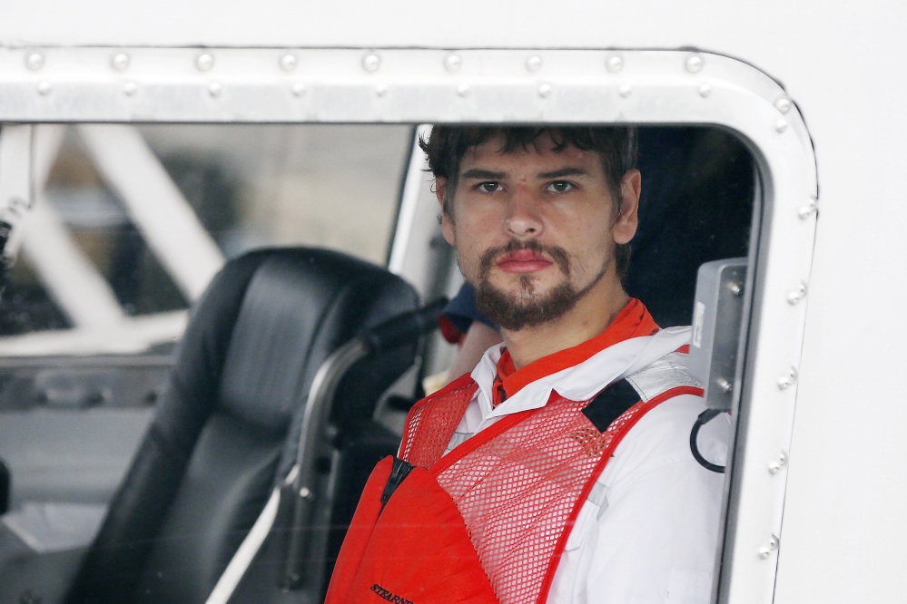 Nathan Carman, 22, arrives in a small boat at the US Coast Guard station in Boston, Tuesday after spending a week at sea in a life raft before being rescued. He had been a suspect in his grandfather's 2013 unsolved slaying.