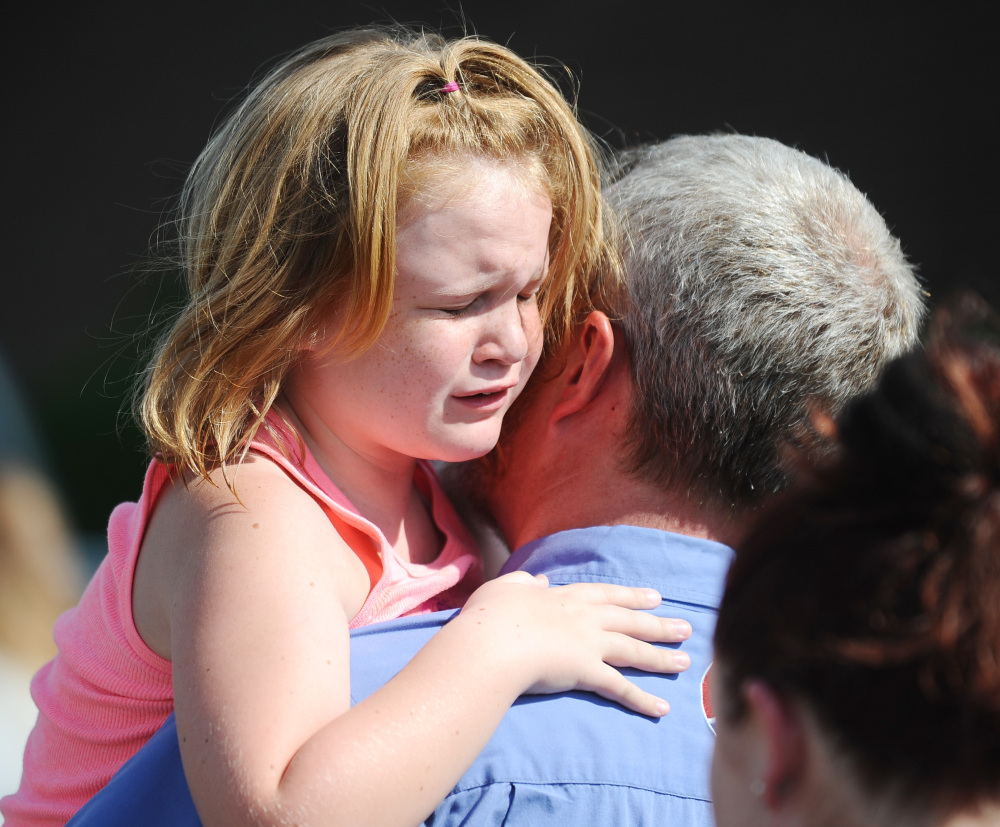 Lilly Chapman, 8, cries after being reunited with her father, John Chapman at Oakdale Baptist Church on Wednesday in Townville, S.C., after a teenager opened fire at the school.