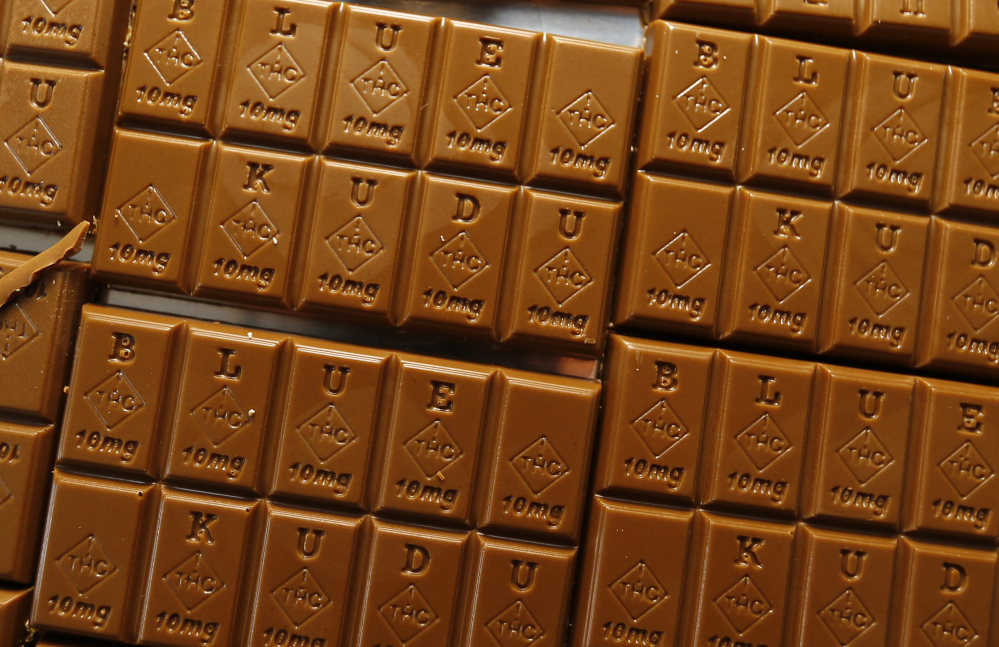 In this Monday, Sept. 19, 2016, photograph, candy bars marked with Colorado's new required diamond-shaped stamp noting that the product contains marijuana are shown in the kitchen of BlueKudu candy in the historic Five Points District of Denver. State officials require the stamp to be put directly on edibles after complaints that the treats look too much like their non-intoxicating counterparts.