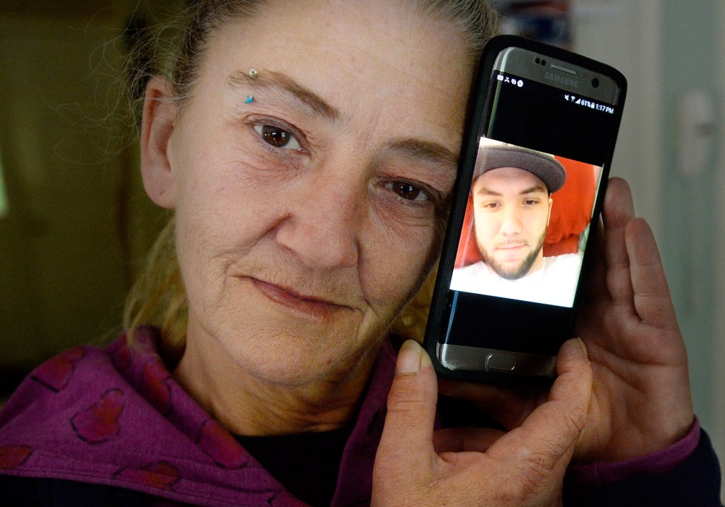 Cheryl Methot, the mother of Jonathon Methot, who was shot Sept. 26 in Biddeford, holds a phone with a photo of her son. She said her son had struggled with prescription opiate addiction, but was working to get his life back on track, and "was doing really good." Shawn Patrick Ouellette/Staff Photographer
