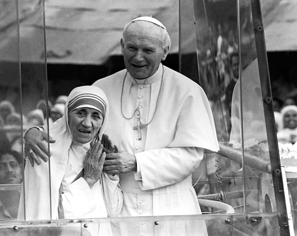 Pope John Paul II, right, holds his arm around Mother Teresa in February 1986 as they ride in the popemobile outside the Home of the Dying in Calcutta, India. When Pope Francis canonizes Mother Teresa on Sunday, he'll be honoring a nun who won admirers around the world and a Nobel Peace Prize for her joy-filled dedication to the "poorest of the poor."