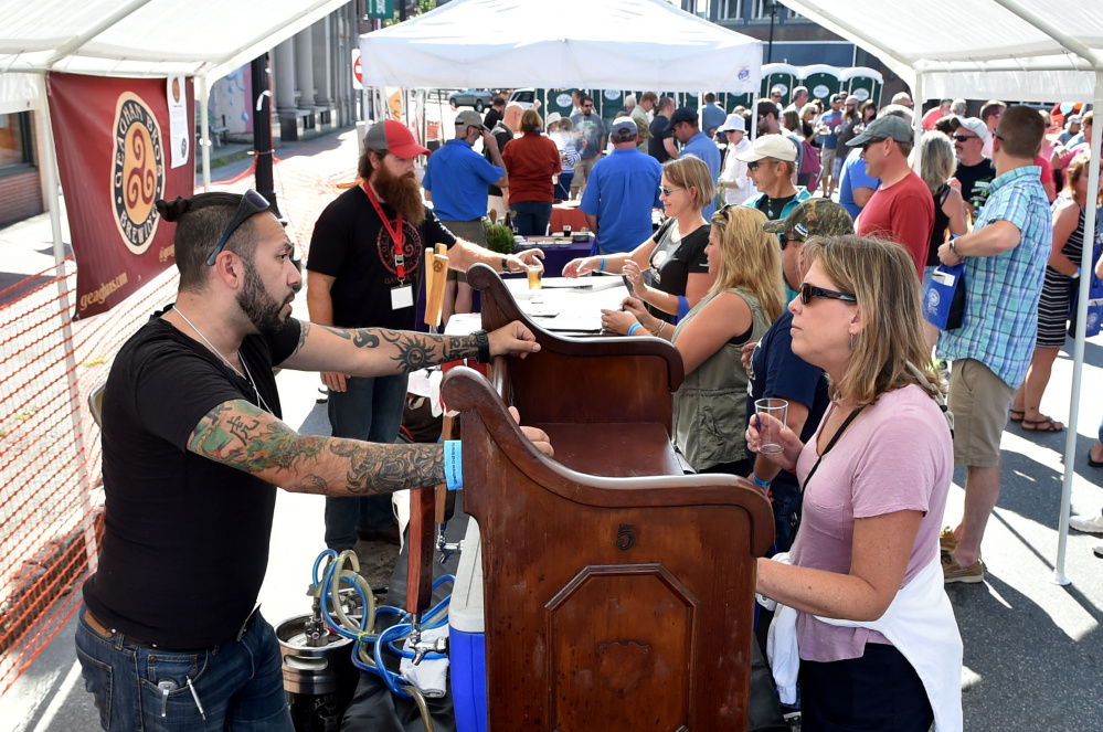 Donna Archambault, right, of Exeter, N.H., talks with David Boucher, head brewer and owner of Crooked Halo Cider, on Saturday at the first Skowhegan Craft Brew Festival on Water Street in downtown Skowhegan.