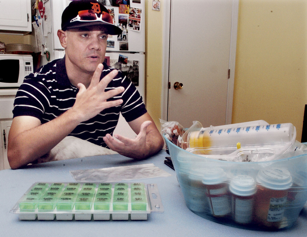 Michael Bowles sits at his Manchester apartment on Wednesday beside a large quantity of medicines he must take following a successful kidney transplant. Bowles, facing end-stage kidney failure and a five-year wait for a deceased donor, took to Facebook in December seeking a living kidney donor and found one in Davine Grantz, of Saco, who was a perfect match.