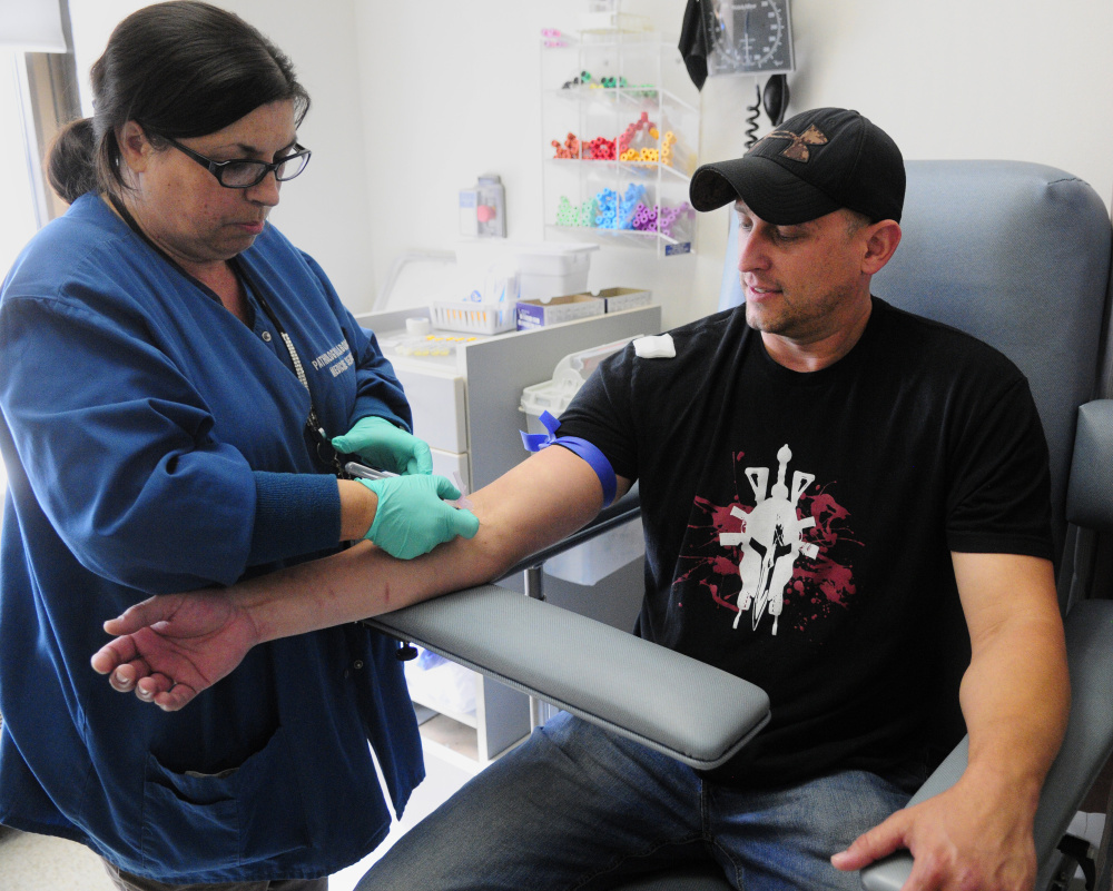 Phlebotomist Del Silva, left, draws blood for tests from the arm of veteran Josh Grass, of Whitefield, on Thursday in Building 200 at the VA Maine Healthcare Systems-Togus.
