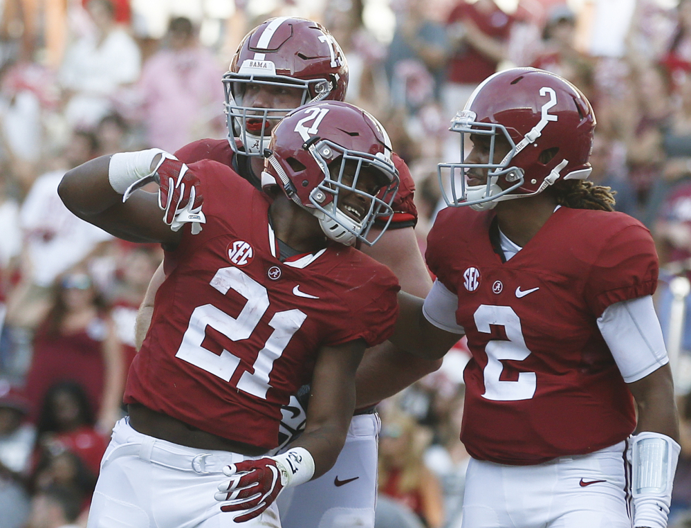 Alabama running back B.J. Emmons, center, quarterback Jalen Hurts, right, and offensive lineman Jonah Williams, back, celebrate after Emmons scored against Western Kentucky on Saturday in Tuscaloosa, Alabama.