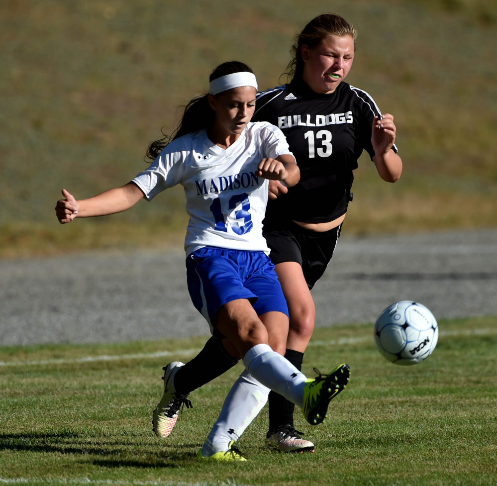 Madison freshman Emily Edgerly (13) looks to pass as Hall-Dale sophomore Grace Begin defends during a Mountain Valley Conference game Tuesday afternoon. Madison won, 6-0.