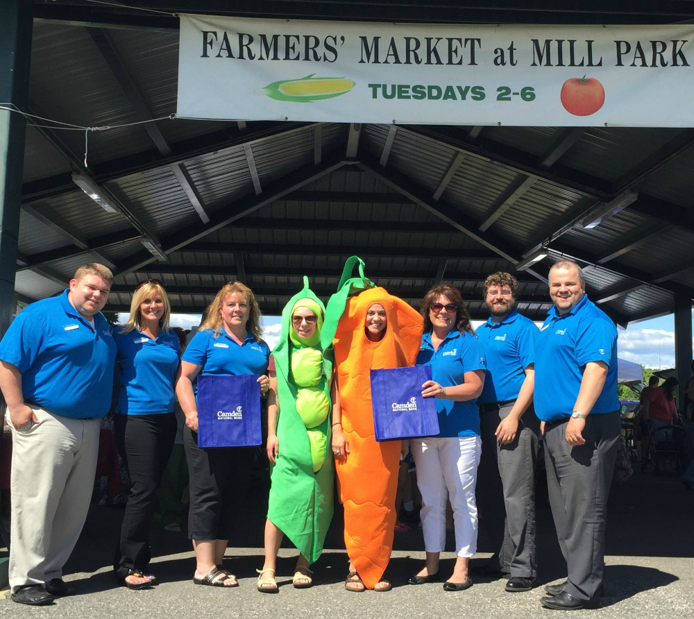 Camden National bank employees from the Augusta area pose with a pea and carrot from WIC at the Augusta Farmers' Market in July. From left are Wes Huckey, Donna York, Trisha Harriman, Brookes Smith, Janessa Smith, Nancy Tracy, Wes Littlefield and Brent Vicnaire.