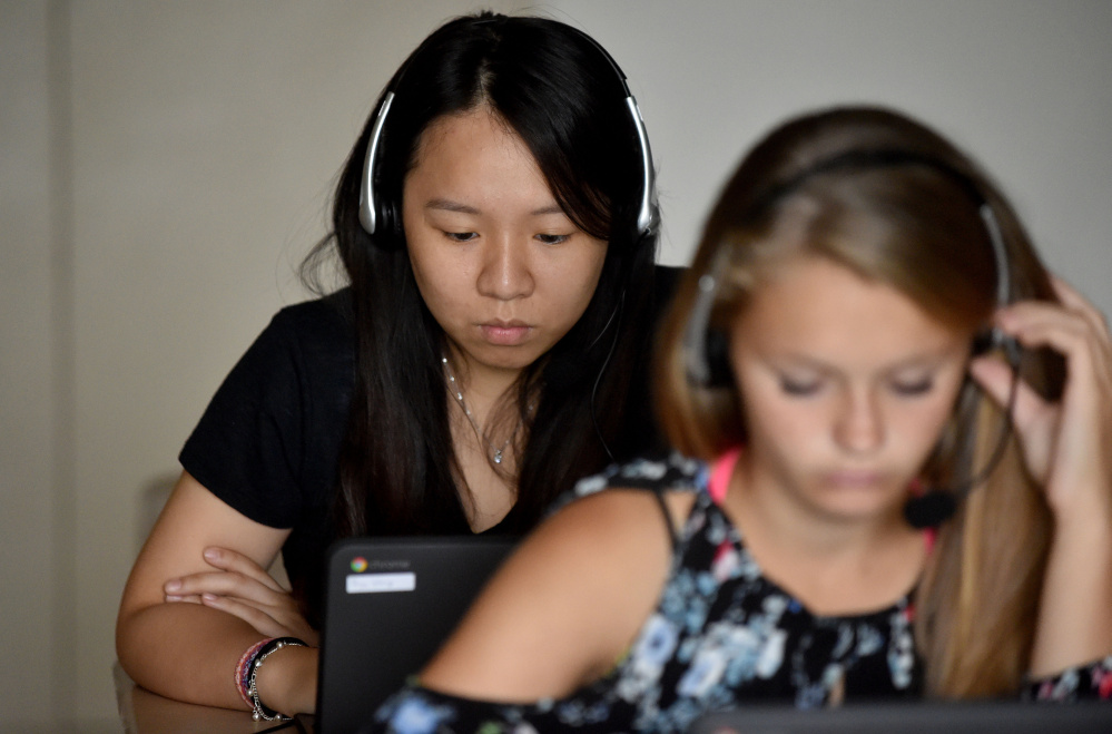 Paige Wong, 17, senior exchange student from Taiwan, back, works through Rosetta Stone lessons during Spanish language class at Madison Area Memorial High School on Sept. 8.