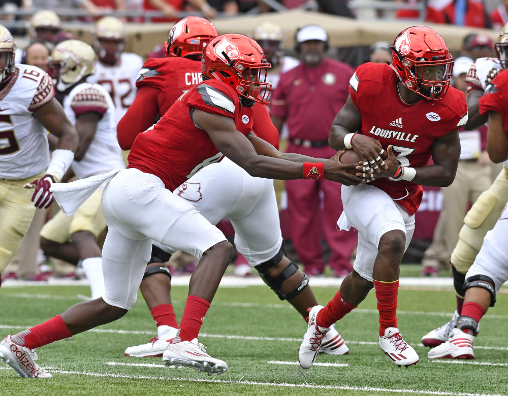Louisville quarterback Lamar Jackson (8) fakes a handoff to Brandon Radcliff (23) during the first quarter against Florida State on Saturday in Louisville, Kentucky.