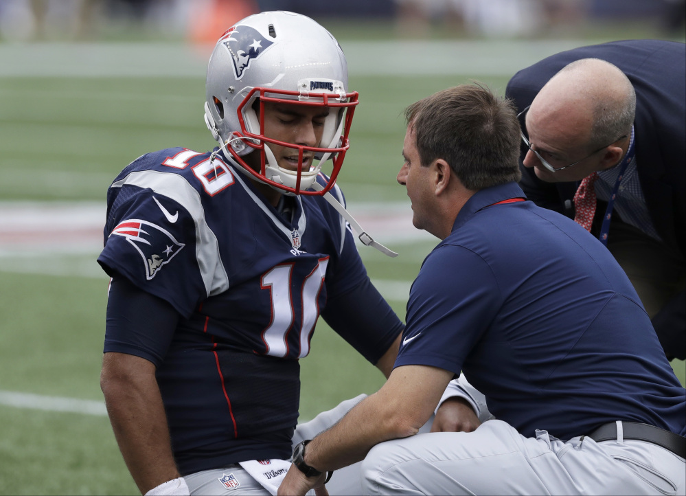 New England Patriots quarterback Jimmy Garoppolo receives attention after an injury during the first half against the Miami Dolphins on Sunday in Foxborough, Massachusetts.