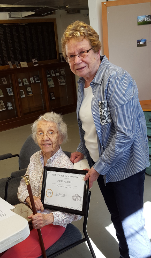 SIDNEY — The Boston Post cane was presented to Polly Furber, left, by Sidney Historical Society President Sally Nelson. Furber, 96, who has lived for some time in a historic house in Sidney, is the oldest resident of the town. Furber has given the society countless hours of her time researching deeds.