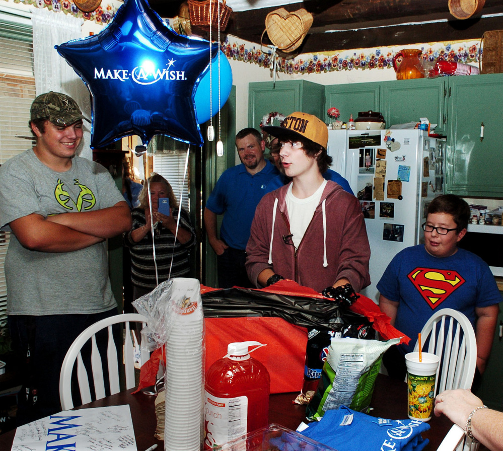 Michael Welcome, center, was the center of attention at a surprise party for him and the unveiling of his remodeled bedroom at his home in Madison on Tuesday. Welcome suffers from cystic fibrosis and received the new room through the Maine Make-A-Wish organization with help from Skowhegan Savings Bank.