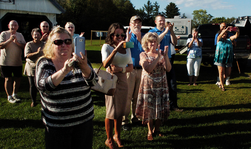 Friends, family and supporters take photos and clap as Michael Welcome arrives at his home in Madison in a limousine on Tuesday.