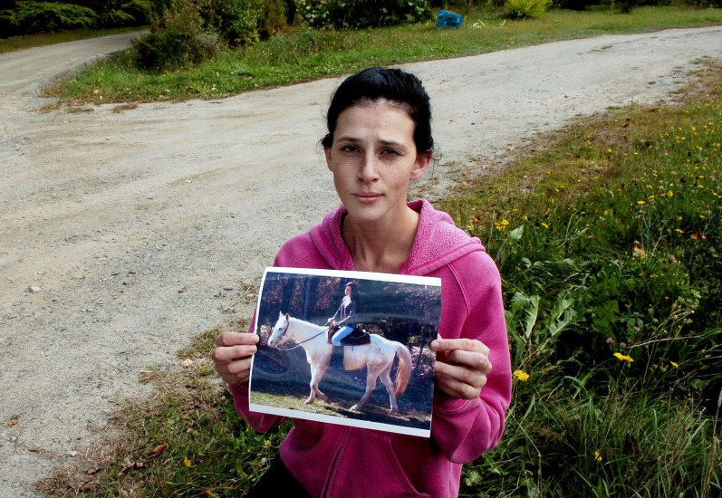 Sierra Miner holds a photograph of her 4-year-old mare, Lucy, last Thursday at the spot she said someone drove onto her property in Canaan a day earlier and struck and dragged the tethered horse to death. But police investigating the case say they haven't found any evidence a vehicle was involved in the horse's death.