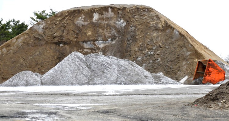 Light colored salt is stored beside a large pile of sand used for winter road work at the Winslow Public Works garage on April 12.